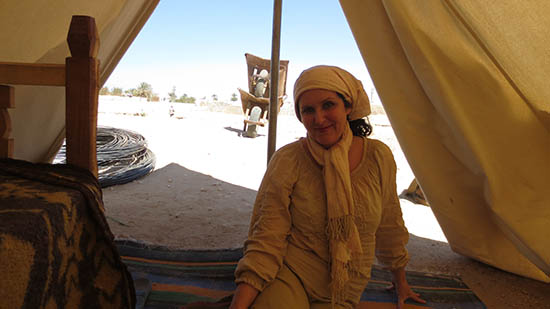 Woman sitting on floor of a tent.