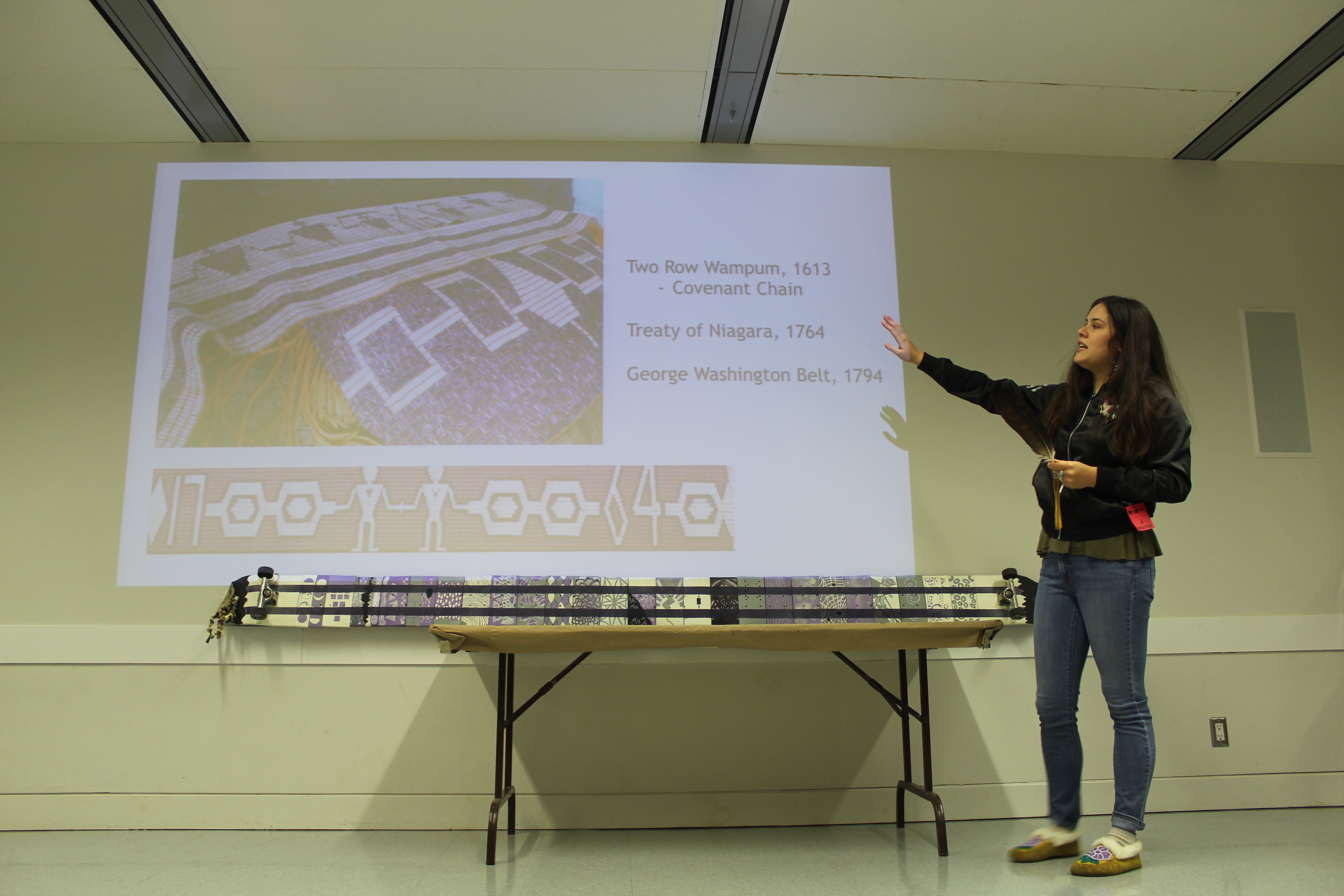 A woman lecturing in front of a screen