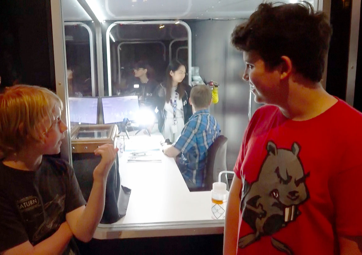 two students observe a spider being milked for venom