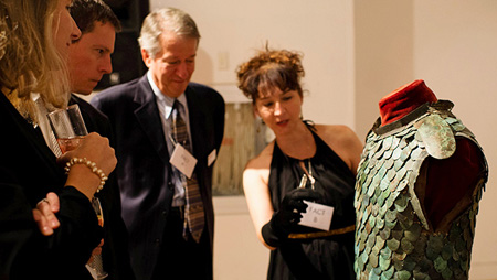 People examining a piece of armour 