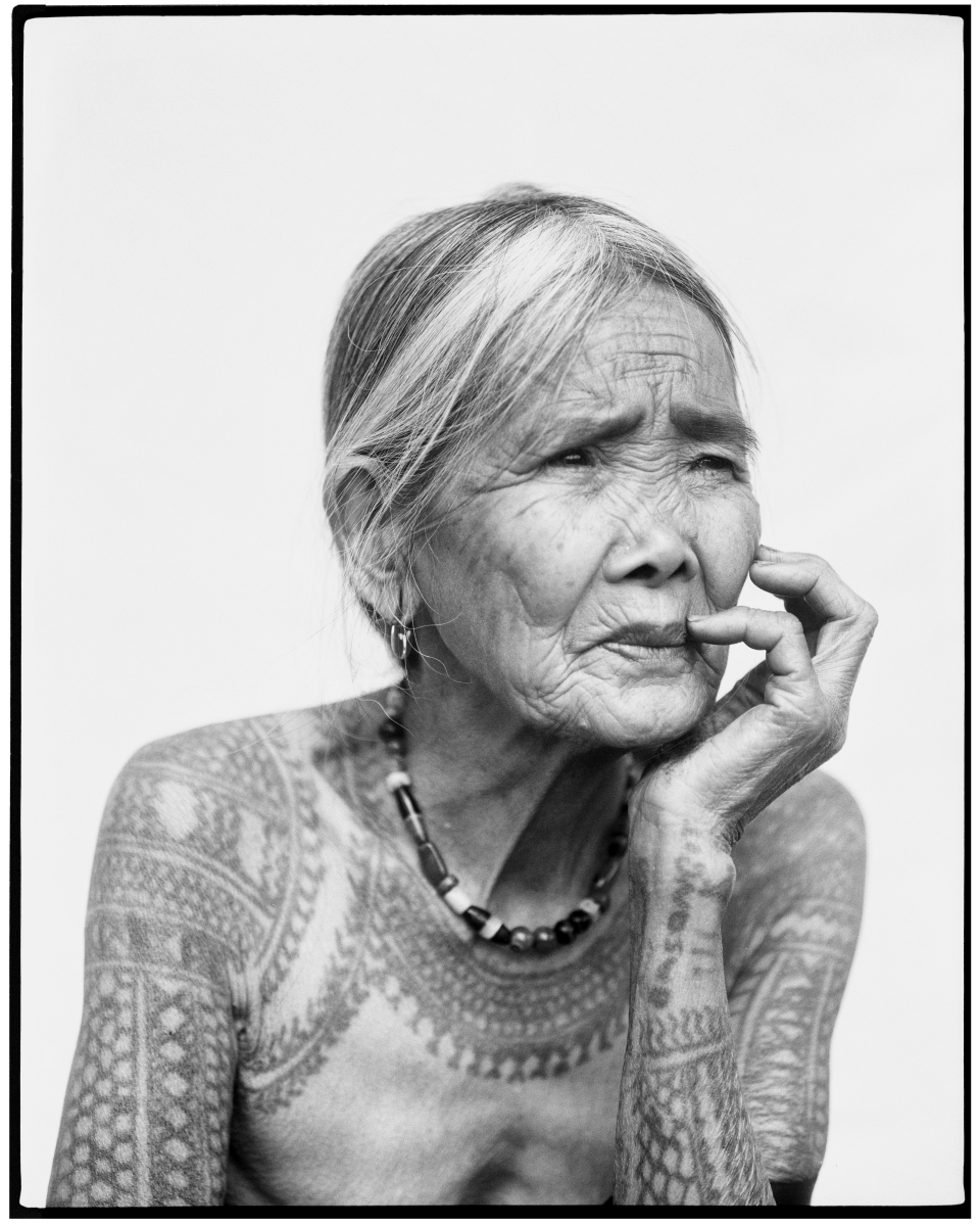 Photo: Portrait of woman, Fang-od Oggay, displaying her tattoos