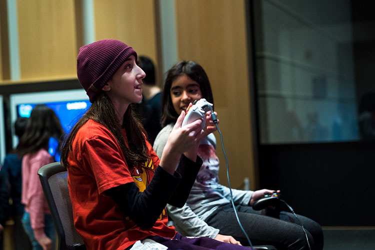 Two women holding a game console