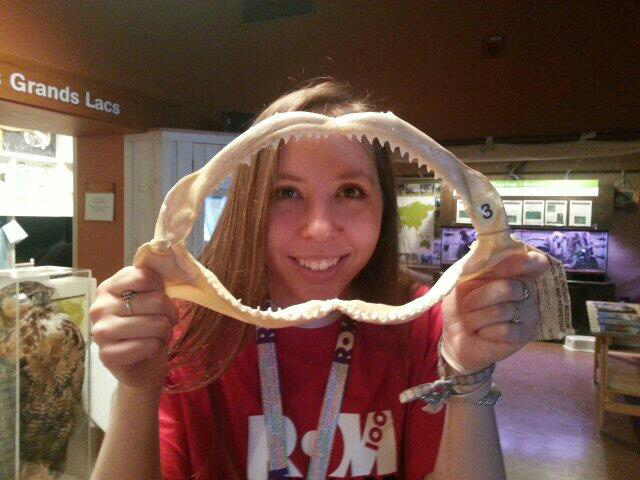 Woman in Hands-On Gallery holding a jaw bone with sharp teeth.