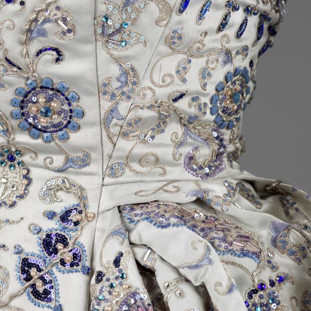 Photo of a white gown with blue jewelled detailing