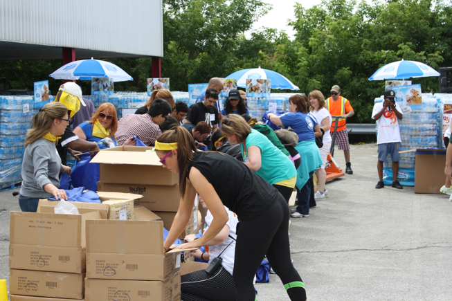 People outside organizing boxes of water bottles donated by Nestlé.