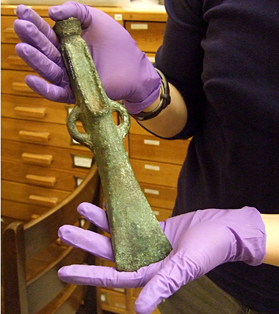 Kay with bronze age axe Gloved hands holding an axe-head