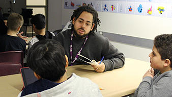 Intern working with students in the maker space.