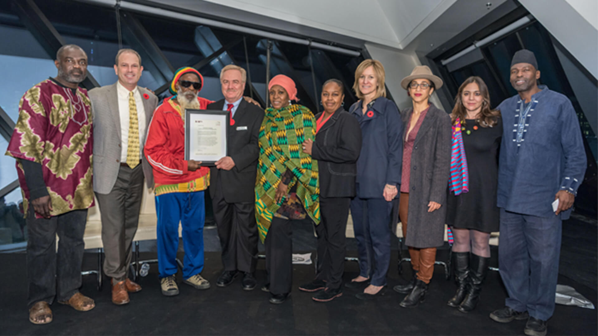 A group of ten people standing in front of the ROM’s Crystal following the Museum’s remarks and apology for the harm endured by members of the African-Canadian community.