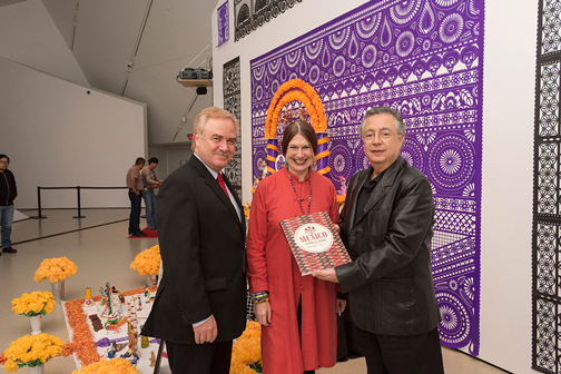 Mexican Consul General Mauricio Toussaint (right) receives a copy of Mexico: Clothing & Culture from ROM Interim Director & CEO Mark Engstrom and book author Chloë Sayer.