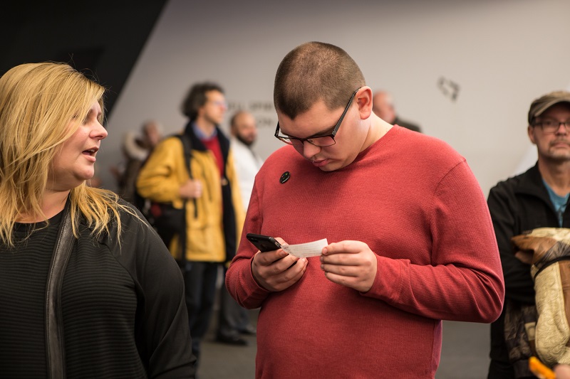 Participant studies his ticket voucher and the ROM MagnusCards instructions on how to purchase his ticket to the ROM.