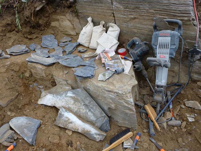 Field equipment including jackhammers, and fossils being labeled and wrapped before packing.