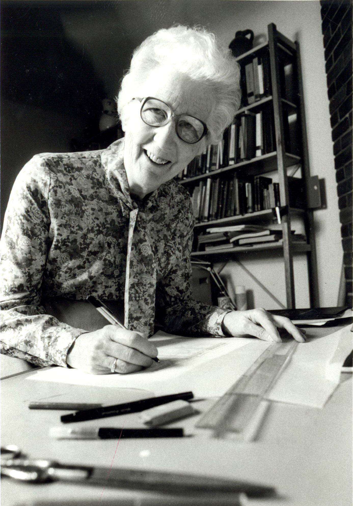 Black and white photo of Dorothy Burnham at a drafting table