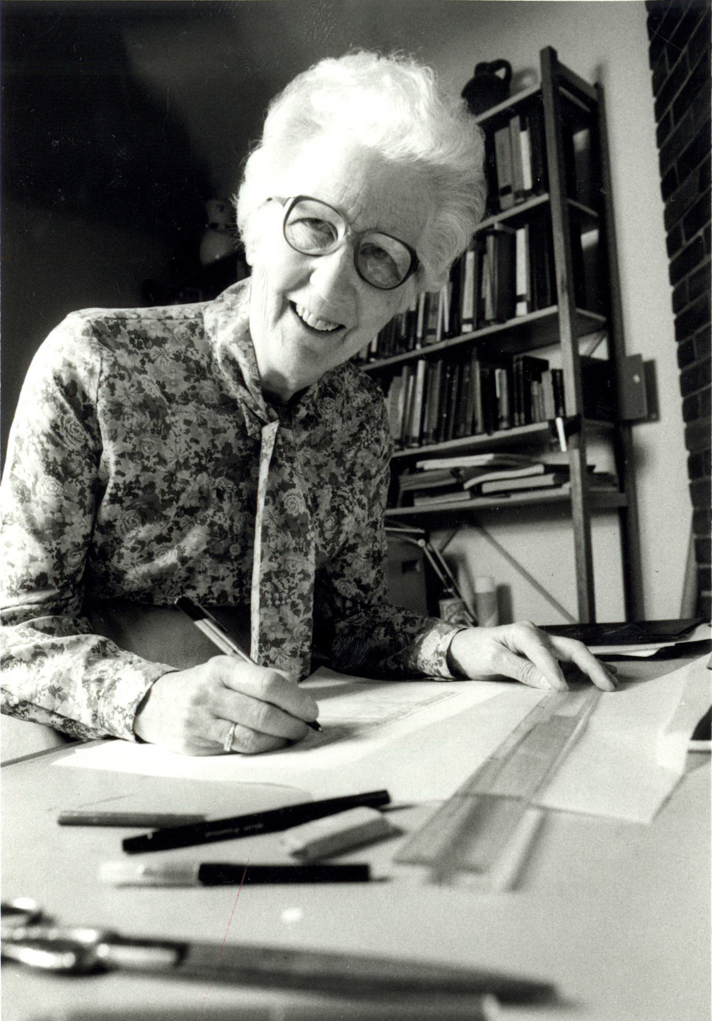 Black and white photo of Dorothy Burnham at a drafting table
