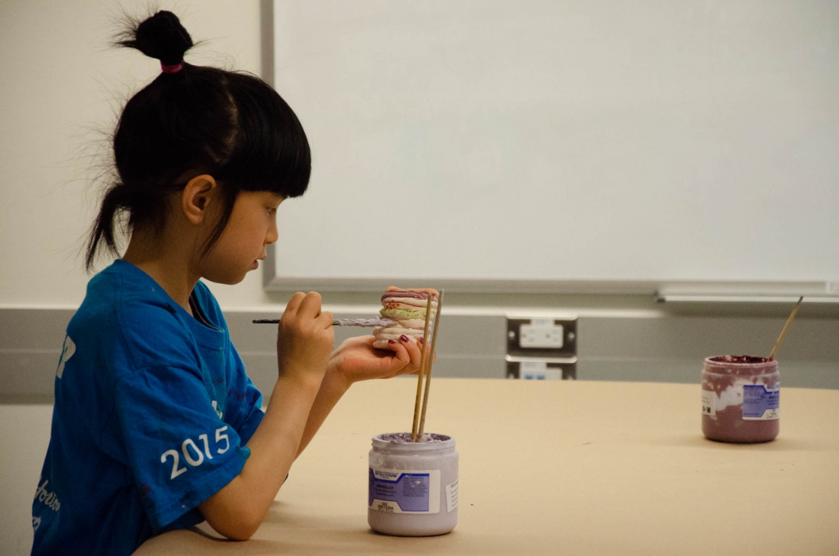 Une étudiante peint son pot en céramique en classe. Image : Michael Berger