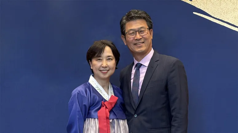 Woman and man in front of a blue background