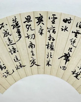 Fan-shaped artwork featuring traditional Chinese calligraphy in bold black ink on a cream background, with a red seal stamp