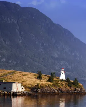 A lighthouse with a mountain in the background.