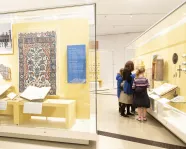 Une famille examine un objet du Moyen-Orient dans la vitrine d'une galerie.