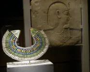 Gallery shot of Eye of the Beholder with collar and relief sculpture in foreground under spotlight, W. Garfield Weston Exhibition Hall
