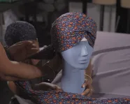 A face mask and turban on a bust.