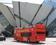 Double-decker bus passing by the Royal Ontario Museum.
