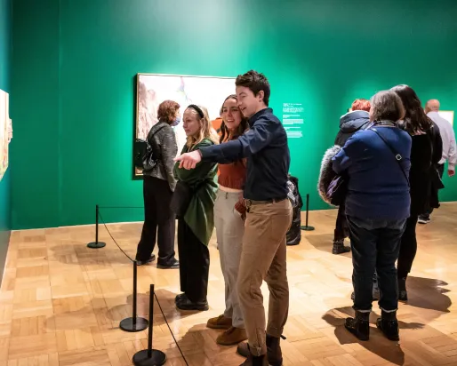 A young couple smile whiling looking at a picture the man is pointing at.
