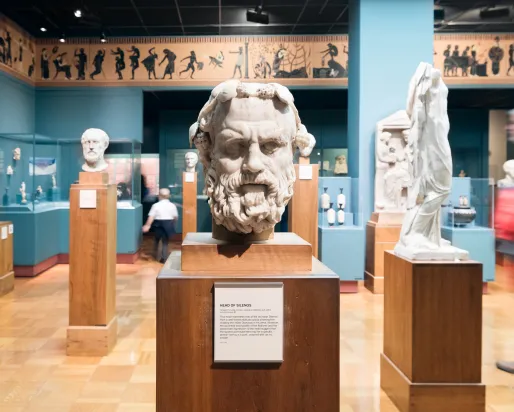 The stern face of Silenos carved in marble stares