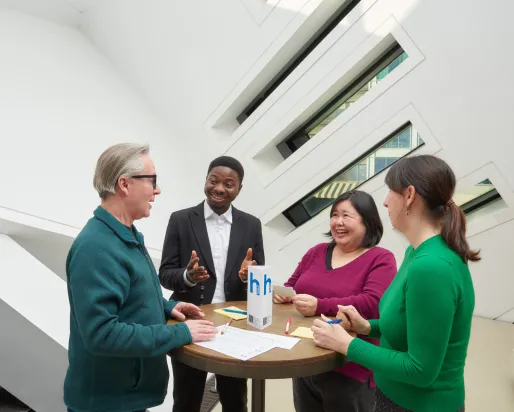 four people sitting at a table, having a fun conversation practicing English at the Royal Ontario Museum