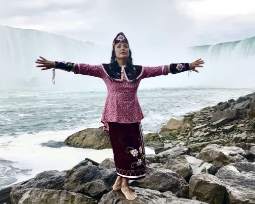 Indigenous lady standing by falls located in Santee 