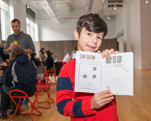 A kid holding up a book.