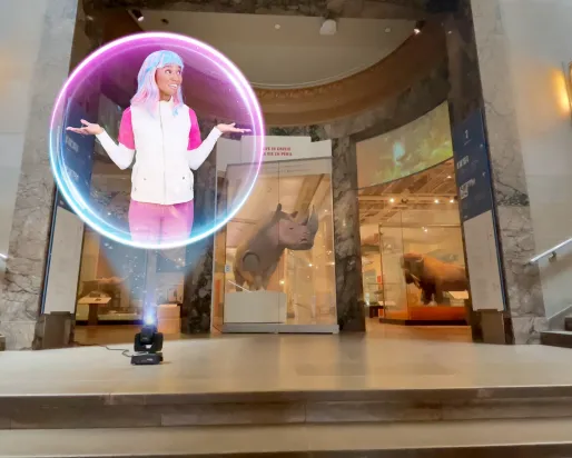 A holographic projection of ECO, the Earth Rangers Communications Operative with colorful hair and a white and pink outfit, appears inside a glowing orb at the Royal Ontario Museum entrance, where she shares engaging lessons about biodiversity and wildlife conservation with visitors.