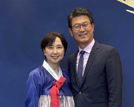 Woman and man in front of a blue background