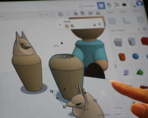 An ipad screen displays a program creating 3D models of canopic jars