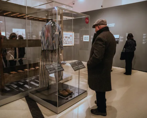 A visitor in the exhibition at ROM looks in at a display case.