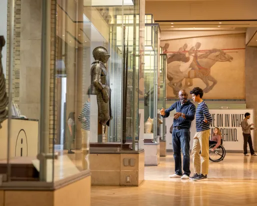 Two people looking and discussing a case of a knife in Currelly gallery