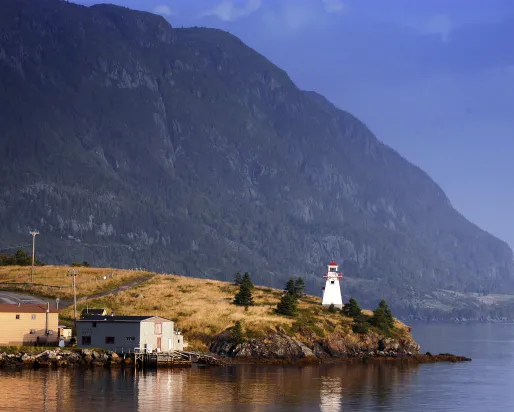 A lighthouse with a mountain in the background.