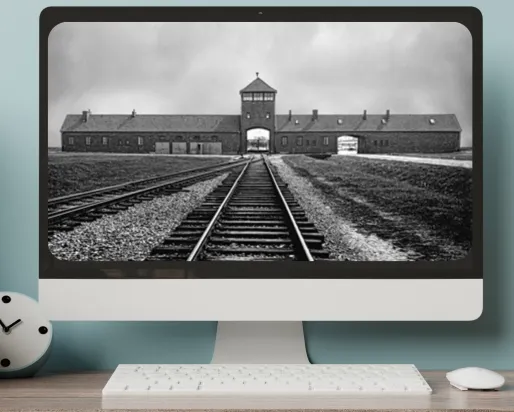 A computer on a desktop shows a black-and-white image railroad tracks leading toward an arched gate beneath a peaked tower.