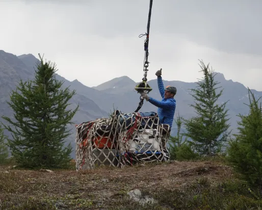 Crates being lifted by helicopter.