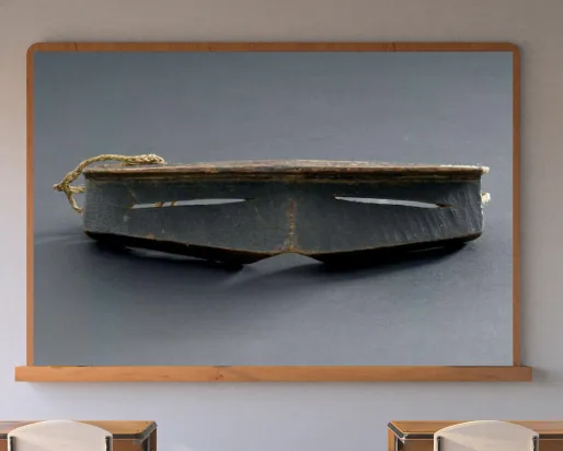 A classroom with a display screen at the front. The screen shows iggaak (snow goggles) carved from wood with narrow horizontal slits for the eyes, and a string at the back.