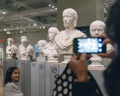 Guest taking a photo of sculptures at ROM