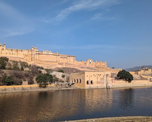 Amber Fort, Jaipur, India. © Noon Plastic, 2024.  Alt text: A fort on the banks of a lake.
