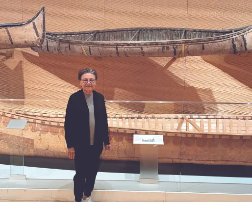 Barbara Nolan, the inaugural Elder in Residence, stands in the Daphne Cockwell Gallery dedicated to First Peoples art & culture. 