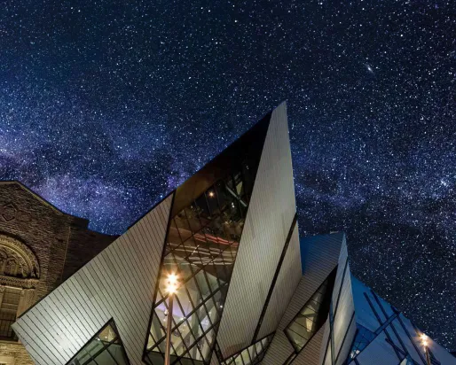 A museum is silhouetted against a dark sky full of brilliant stars