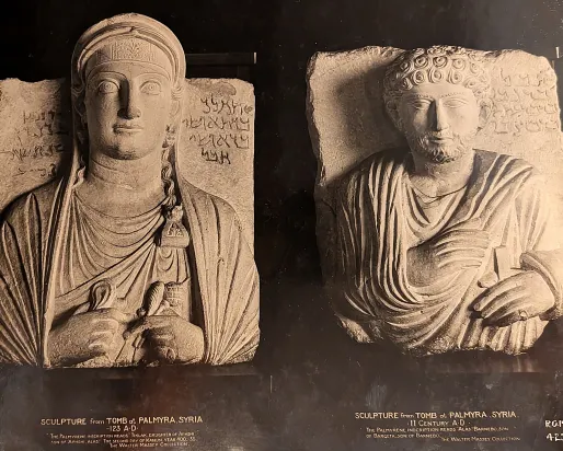 Left: Limestone stele depicting a woman with long hair and rectangular face; right: Limestone stele depicting a man with curly hair and beard, both wearing draped garments and seated.