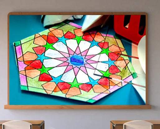 A screen on a classroom wall shows a colourful geometric pattern