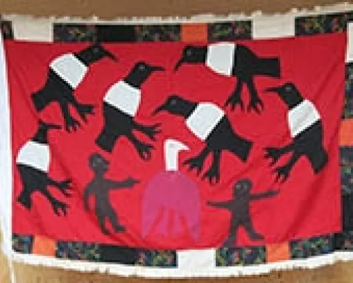 People holding up a handmade flag depicting birds.
