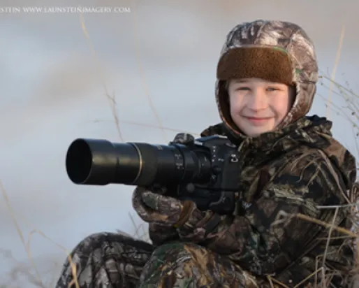 Ten-year-old wildlife photographer Josiah Launstein sits bundled up and ready to take the shot.

