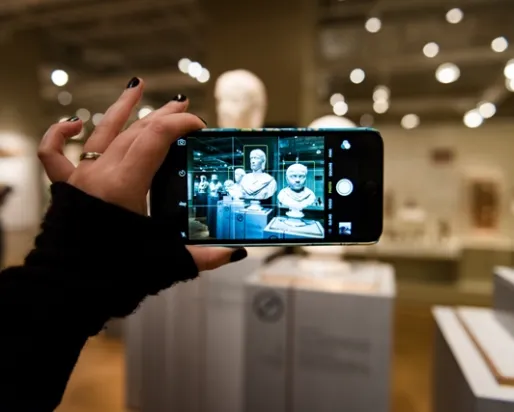 Image of a visitor taking a photo on a smartphone
