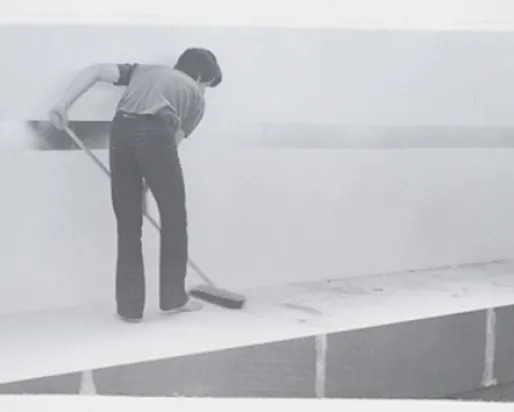 Black and white photo of a man mopping a platform
