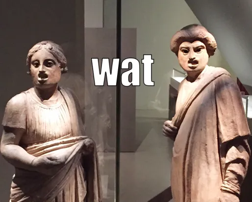 Photo : deux sculptures pompéiennes faisant des grimaces. Légende : Wat.

